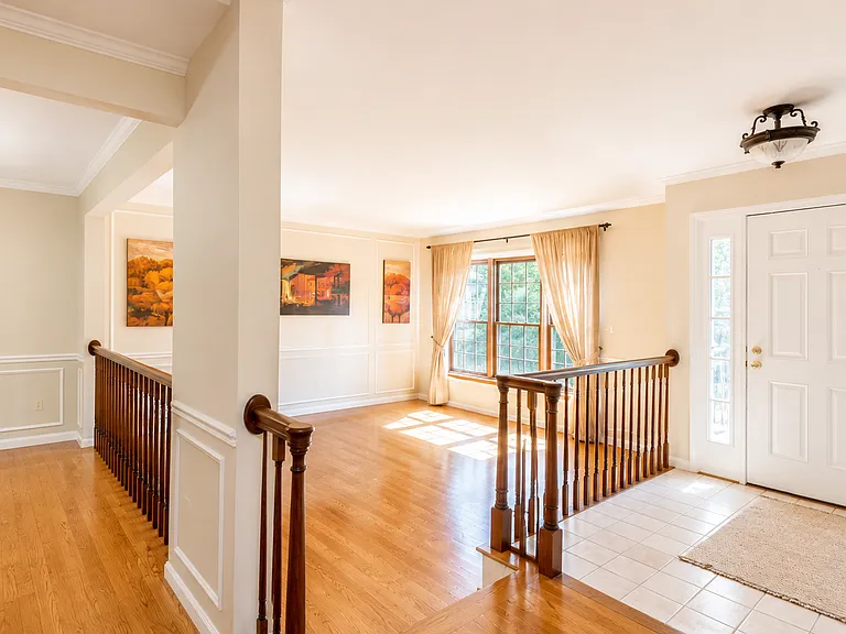 A welcoming foyer opens to spacious living and dining areas with hardwood floors, oversized windows and abundant natural light.