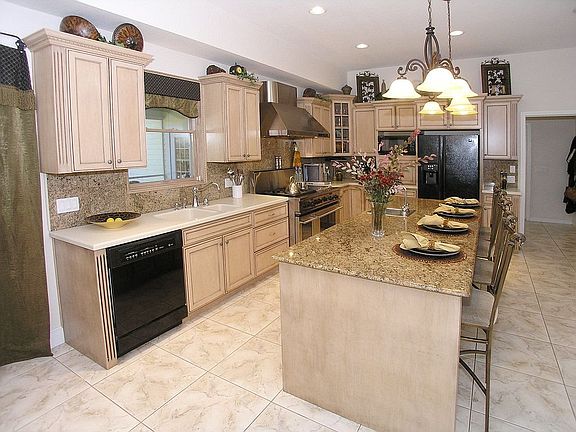 Gourmet Kitchen with commercial gas range, granite island, custom cabinetry
