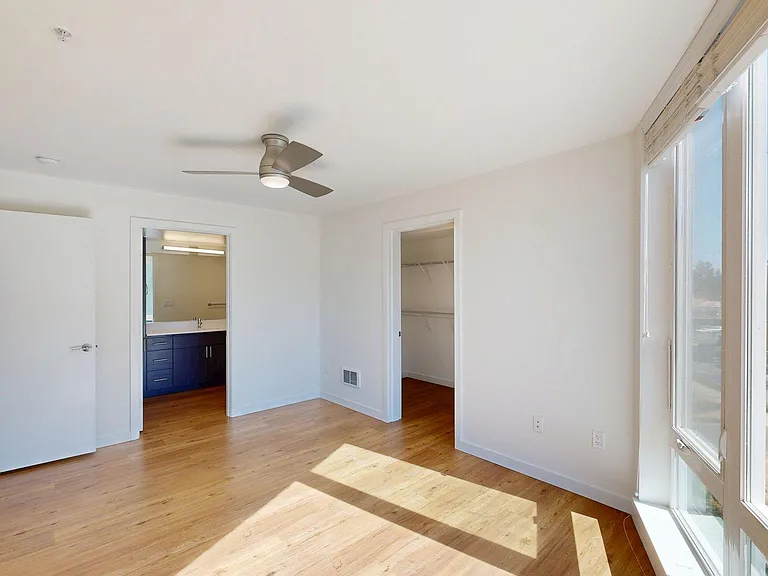 Spacious apartment Bedroom with Wood-Style Flooring.