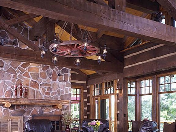 Great room with massive roof timbers, panoramic windows overlooking Norma Lake and stone wall with wood-burning fireplace.