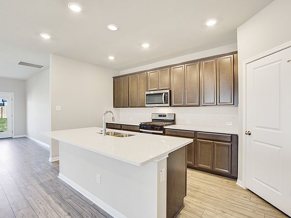 The kitchen features slate-colored cabinets and quartz countertops.