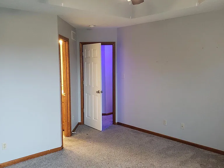 Master bedroom vantage point looking out to hallway, trayed ceiling, ensuite entrance on left