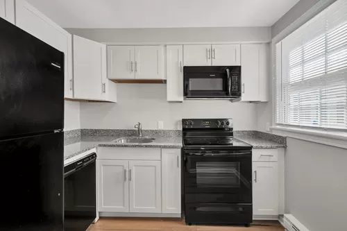 Stunning new renovations include sleek black appliances, and white shaker cabinets. - Linden at Highland Park
