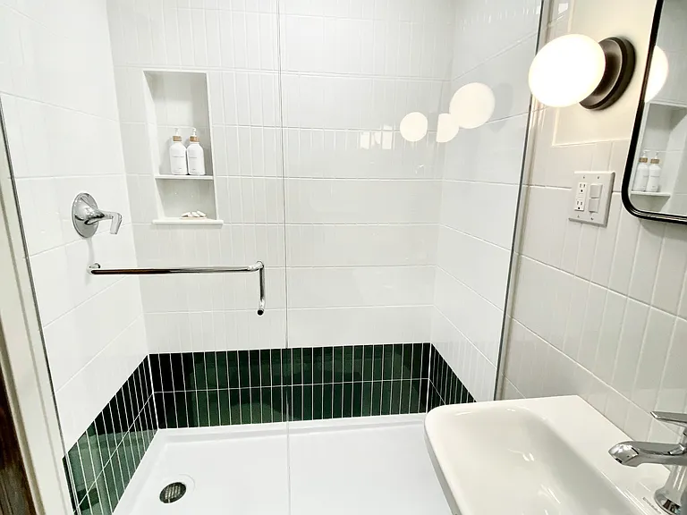 Bright and beautiful second floor bathroom features a pedestal sink and tiled walk in shower.