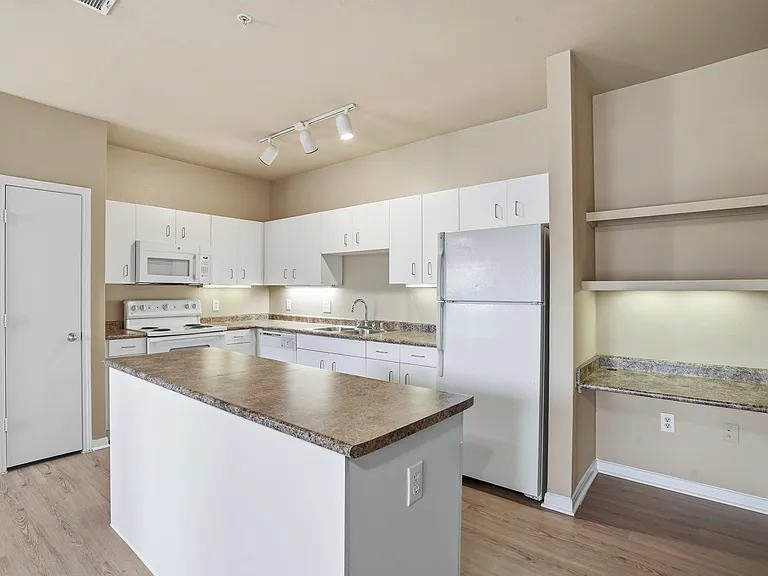 Large Kitchen with amble storage space, built in island, pantry, and built-in desk with shelving.