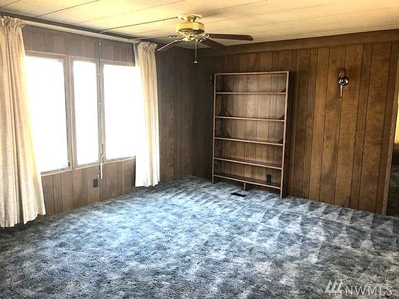 Living room with built in book shelf standing from front door.
