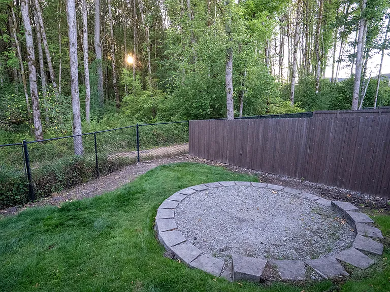 Fully fenced, flat yard with pad for a fire pit or outdoor seating