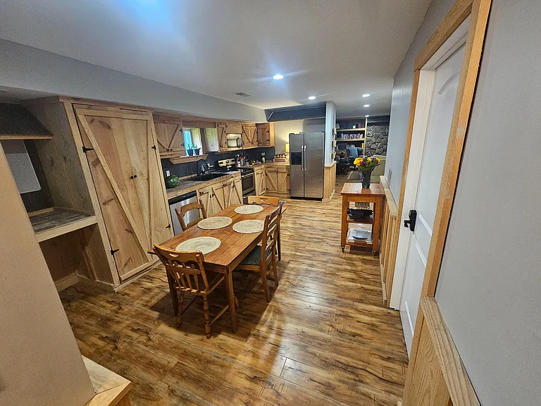 Eat-in kitchen with rustic wood cabinetry, ample counter space, and stainless-steel refrigerator, plus a dedicated dining tab