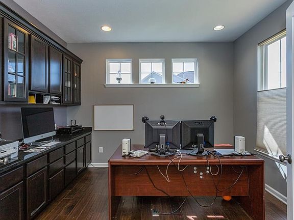 Designated office space with built-in cabinetry and granite countertop.