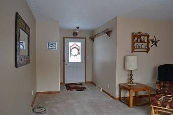 The front entrance to the home, opening up to the living room.  There is a large coat closet to the left of the doorway that is not pictured.  