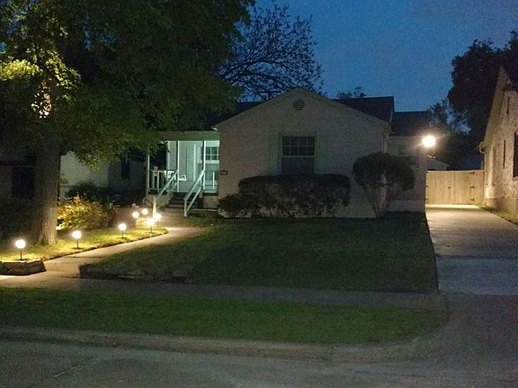 Exterior view at night with side walk lighting, and security lights. Shows one car width driveway. 4 cars can be parked in tandem. 2 spaces on the street in front of the house.