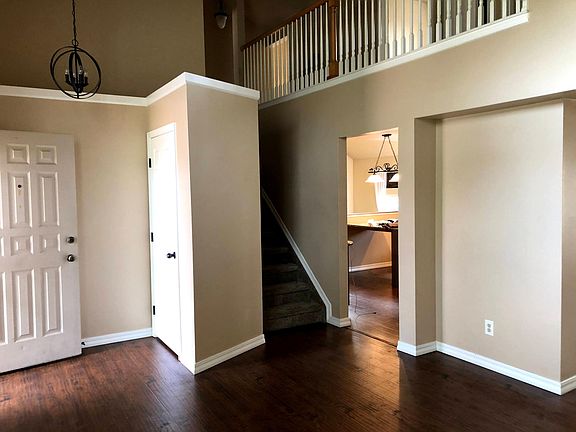 Spacious entryway with coat closet, soaring ceilings, and beautiful hardwood laminate throughout main level