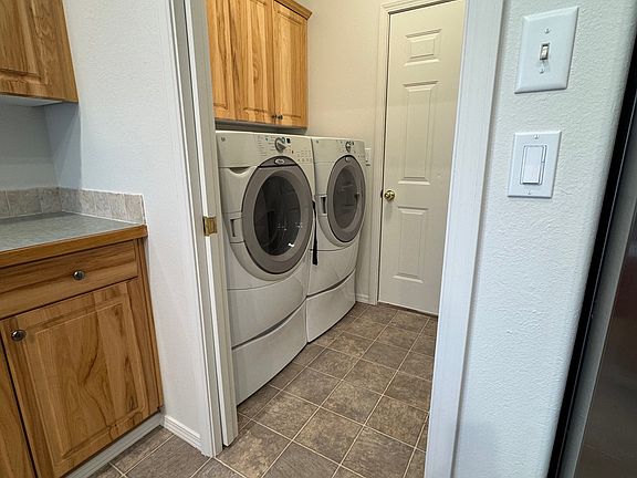 Front load washer and dryer with storage bins