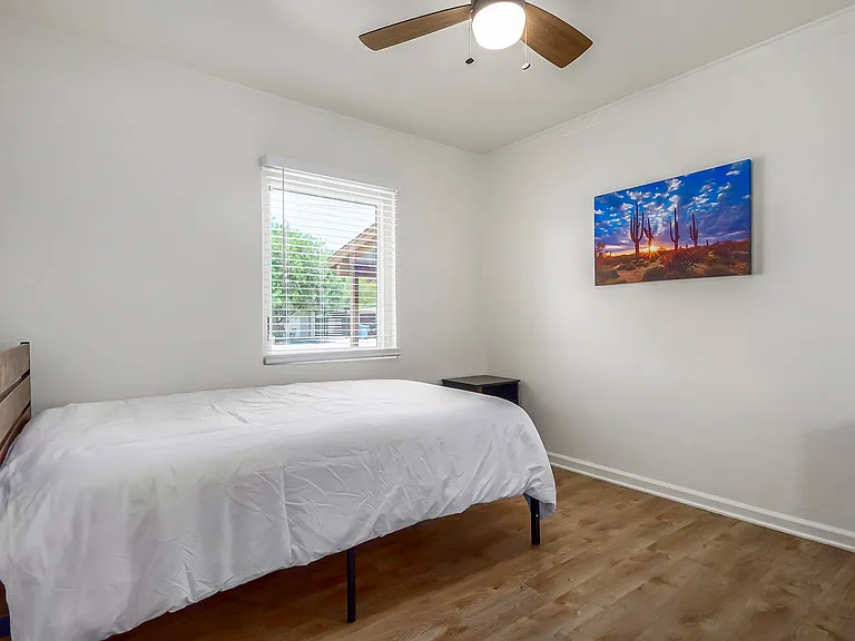 Full size bed and art with nice window facing front of the property.