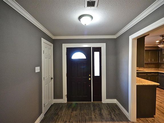 Spacious entry with wood-look tile. Kitchen to the left of entry.