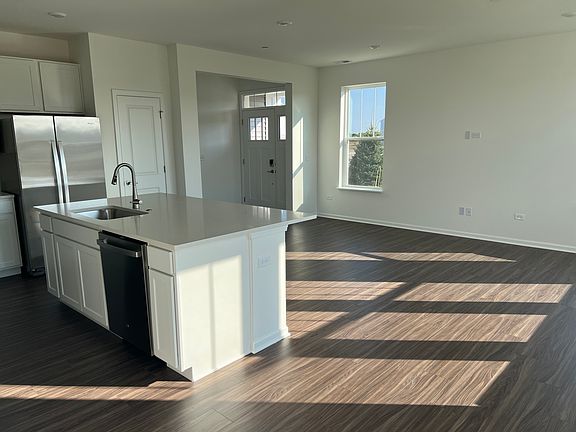 View from Front door into the kitchen area. Huge island with sink , dishwasher and storage space.