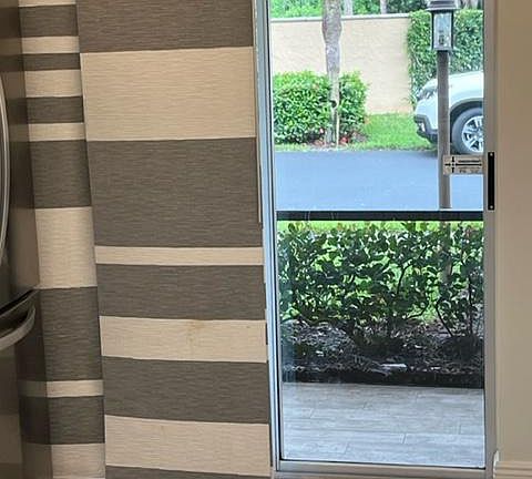 Exterior view from kitchen towards screen enclosed patio.