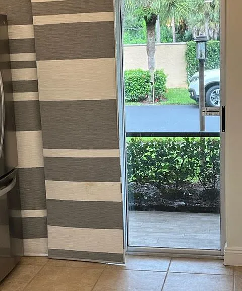 Exterior view from kitchen towards screen enclosed patio.