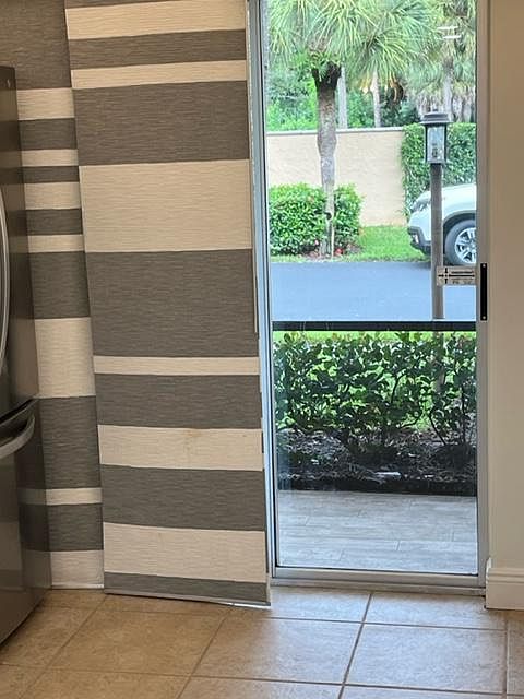 Exterior view from kitchen towards screen enclosed patio.