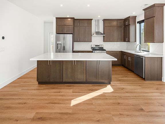 Another view of the massive kitchen with quartz countertops and gas stove.
