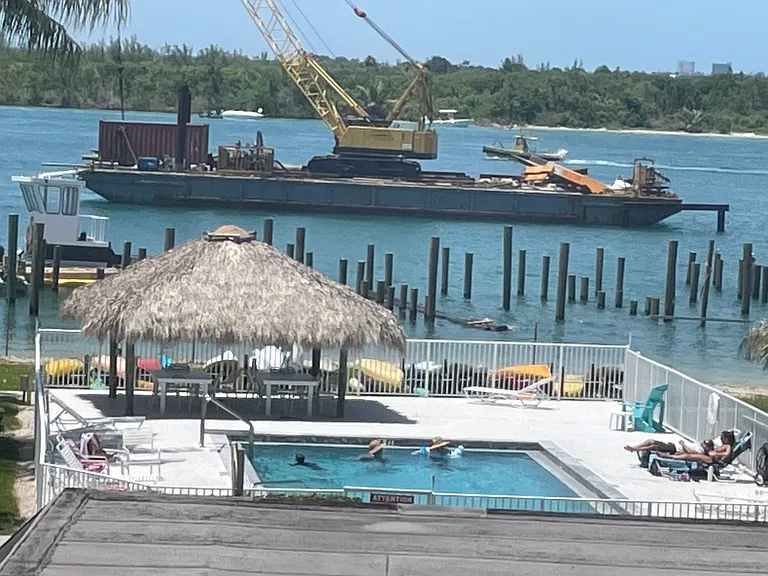 Master bedroom balcony view over Rec. Bldg. & pool with dock construction under way, 07-19-26.