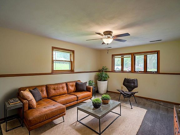 2nd living space/den in lower level with exposed windows, virtually staged