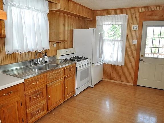 Kitchen has plenty of natural wood cabinets for storage and counter space to prepare delicious family meals.