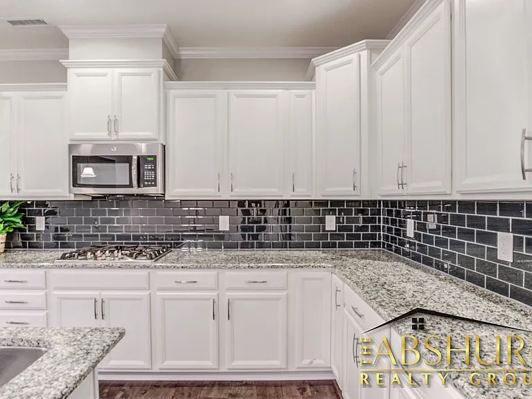 Luxurious open concept kitchen w/ oversized island, granite countertops, SS appliances, 2 wall ovens