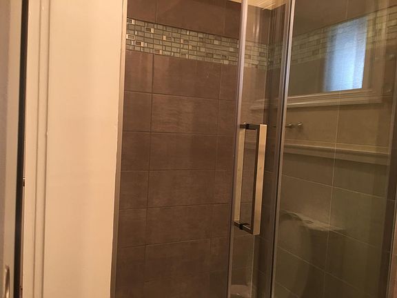 Shower - frameless sliding shower door and custom tilework
