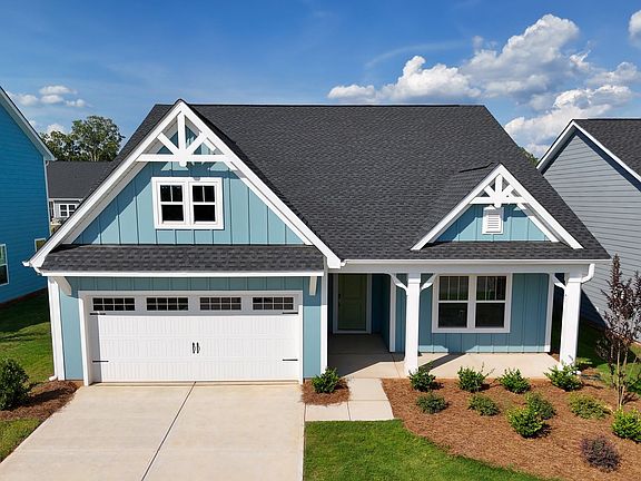 A blue and white house with a garage and a porch.
