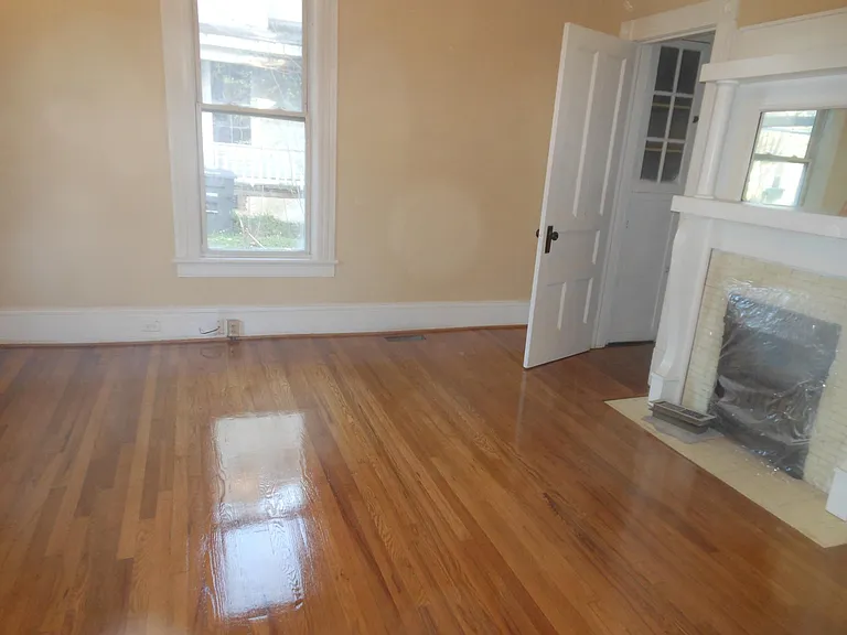 Living room after refinishing floors and painting. High ceilings, attractive moldings.