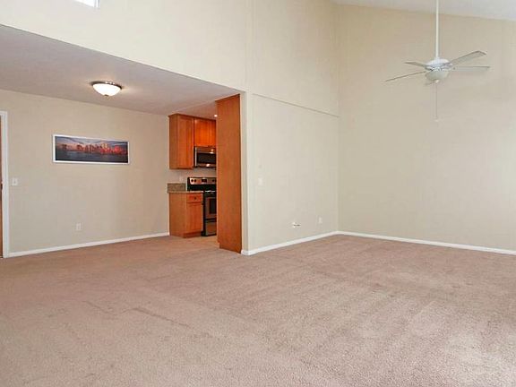 large living area with new laminate floor not shown in picture and ceiling fan.
