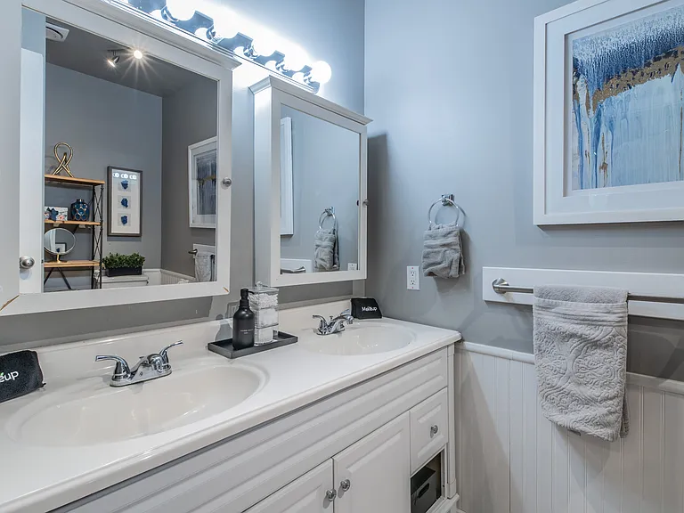 Convenient double vanity with ample storage and lighting.