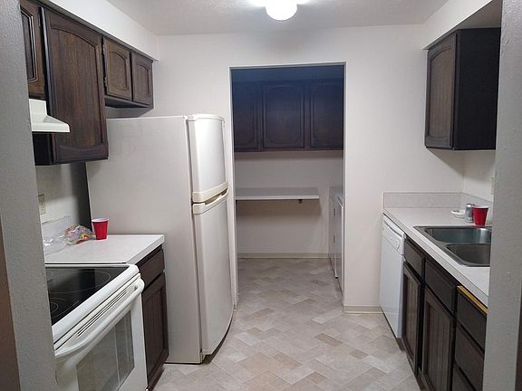 kitchen, laundry room in background, more cabinets not shown in both rooms, Laundry table folds up and down for convenience.
