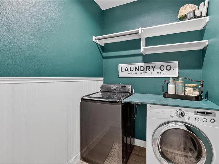 Dedicated laundry area featuring a front-load washing machine and a top-load washing machine
