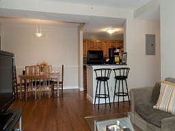 The living room features hardwood floors, a view of the kitchen and dining rooms along with sliding 