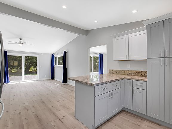 The Kitchen is attached to the living room so that you can spend quality time with your family. 
The cabinet on the right is a large pantry with pull out shelves. Easy to reach your cans that get lost in the back of things.