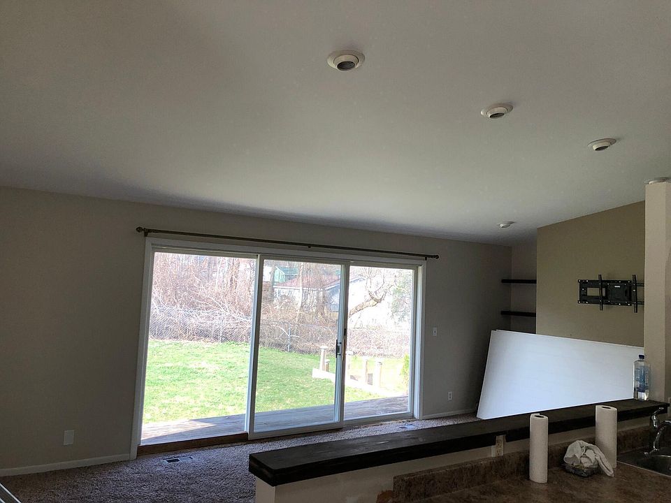 Open concept family room with vaulted ceilings & extra large slider window to expansive wooded yard