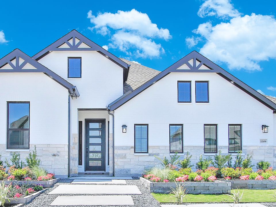 Elegant white facade with black accents, lush landscaping, and stone elements in Oakwood Estates.