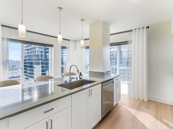Renovated Package I kitchen with white cabinetry, grey quartz countertops, and hard surface flooring