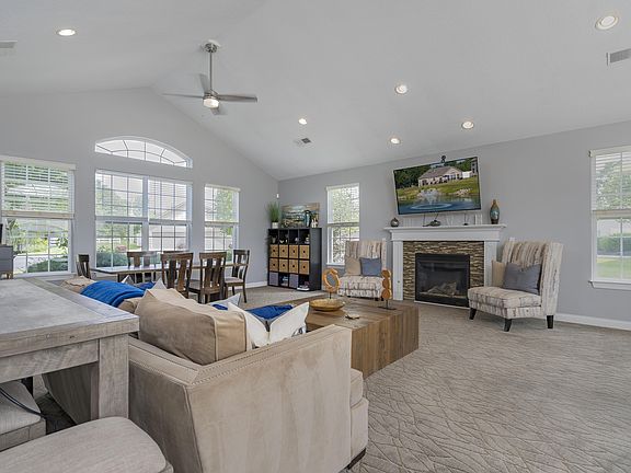 Gather with neighbors in a spacious community lounge, featuring a cozy fireplace and comfortable areas to relax or socialize.
