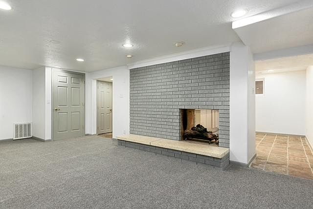 Living room with 2-sided gas fireplace and lots of recessed lighting.