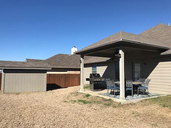 Covered patio fits a round table dining table comfortably. Storage shed for your extra belongings and a freshly stained fence.
