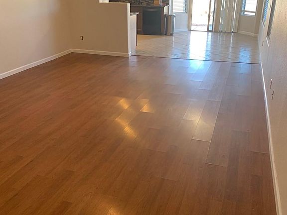 Large living area adjacent to the kitchen with open dining area, sliding door to back yard