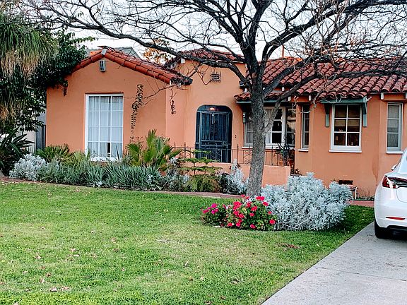 Another view from the front. Perennials, palm trees, and a lovely porch.