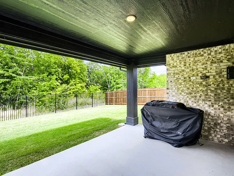 Covered patio with a smooth concrete slab and a painted wood-finish ceiling