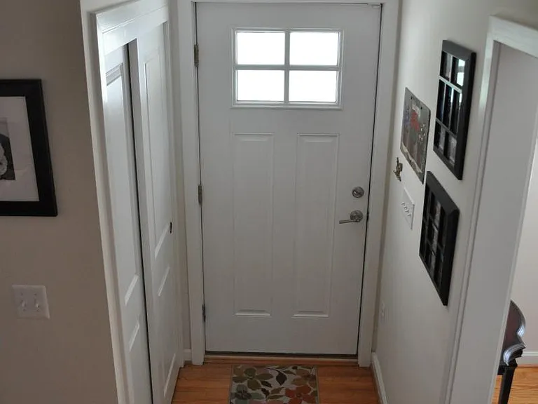 front door with large, double door closet and full glass sto