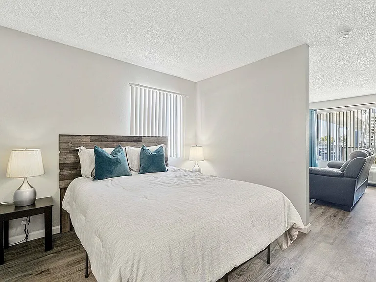 Embrace comfort in this stylish bedroom that seamlessly connects to a welcoming living area.