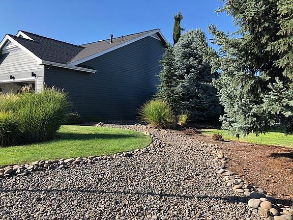 Low maintenance landscaping with riverbed accents