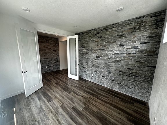 Office with custom brick wall and a view of custom brick in foyer.